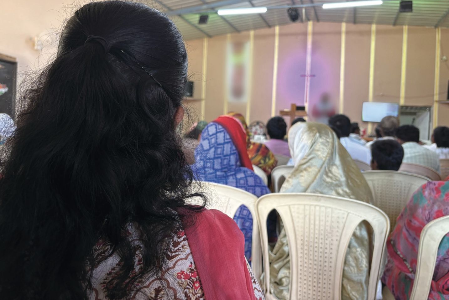 Žena a ďalší ľudia v kostole.