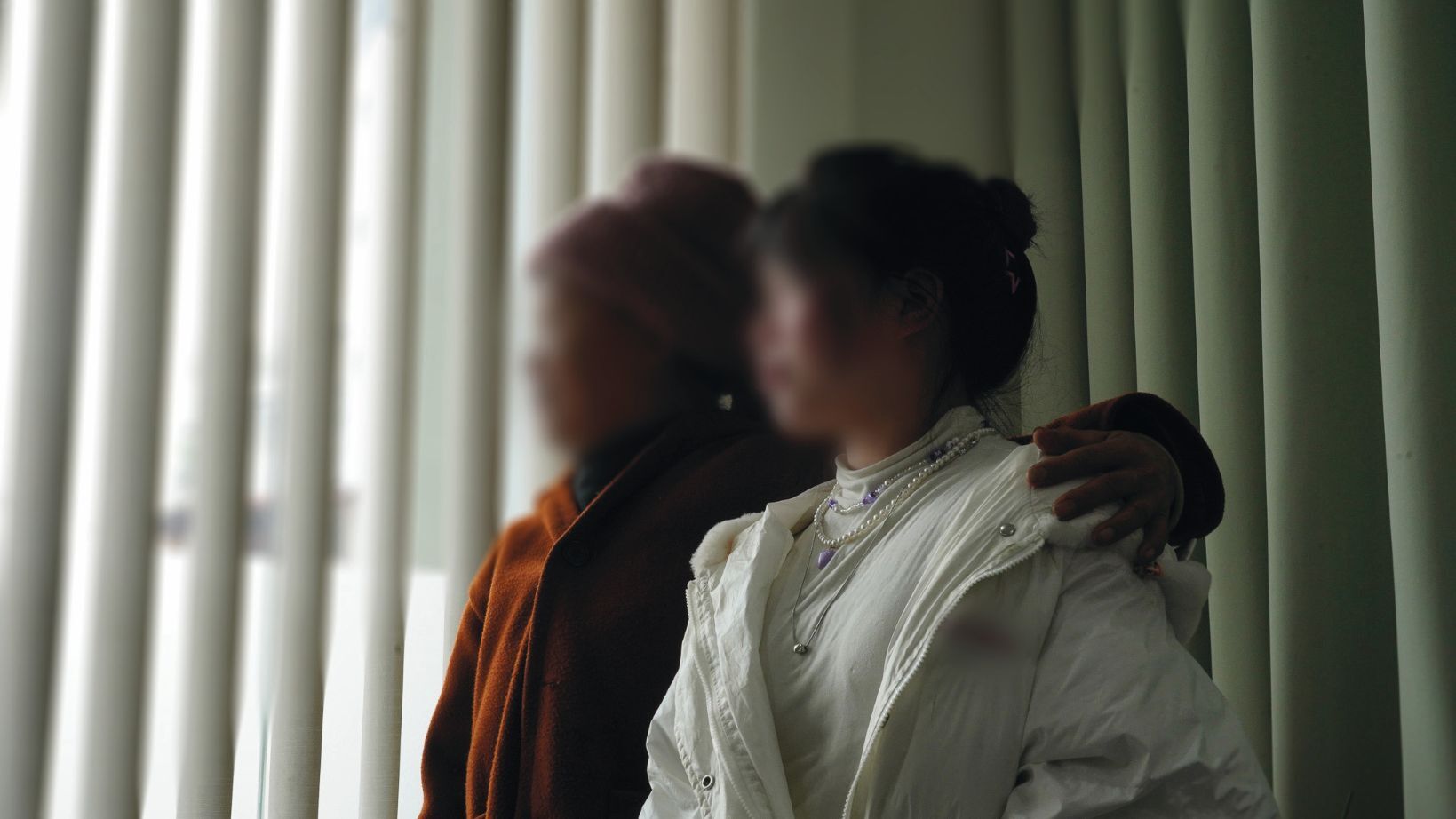 Ngoc a jej dcéra Mien pozerajú z okna.