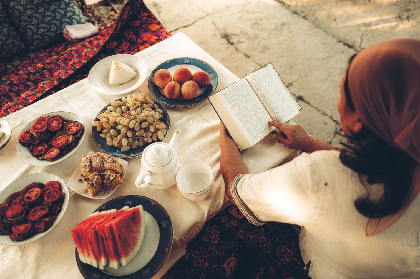 Zaira číta Bibliu pri stole.